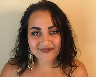 Smiling woman with dark hair and nose and ear piercings