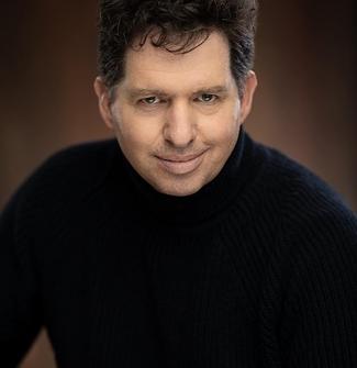 Smiling man with dark hair and black sweater